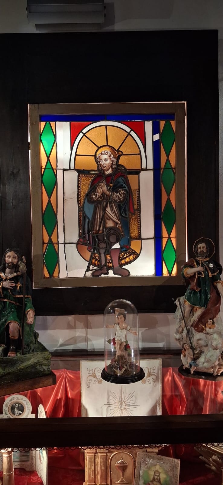 Vetrata policroma raffigurante San Rocco, tra le statue della collezione